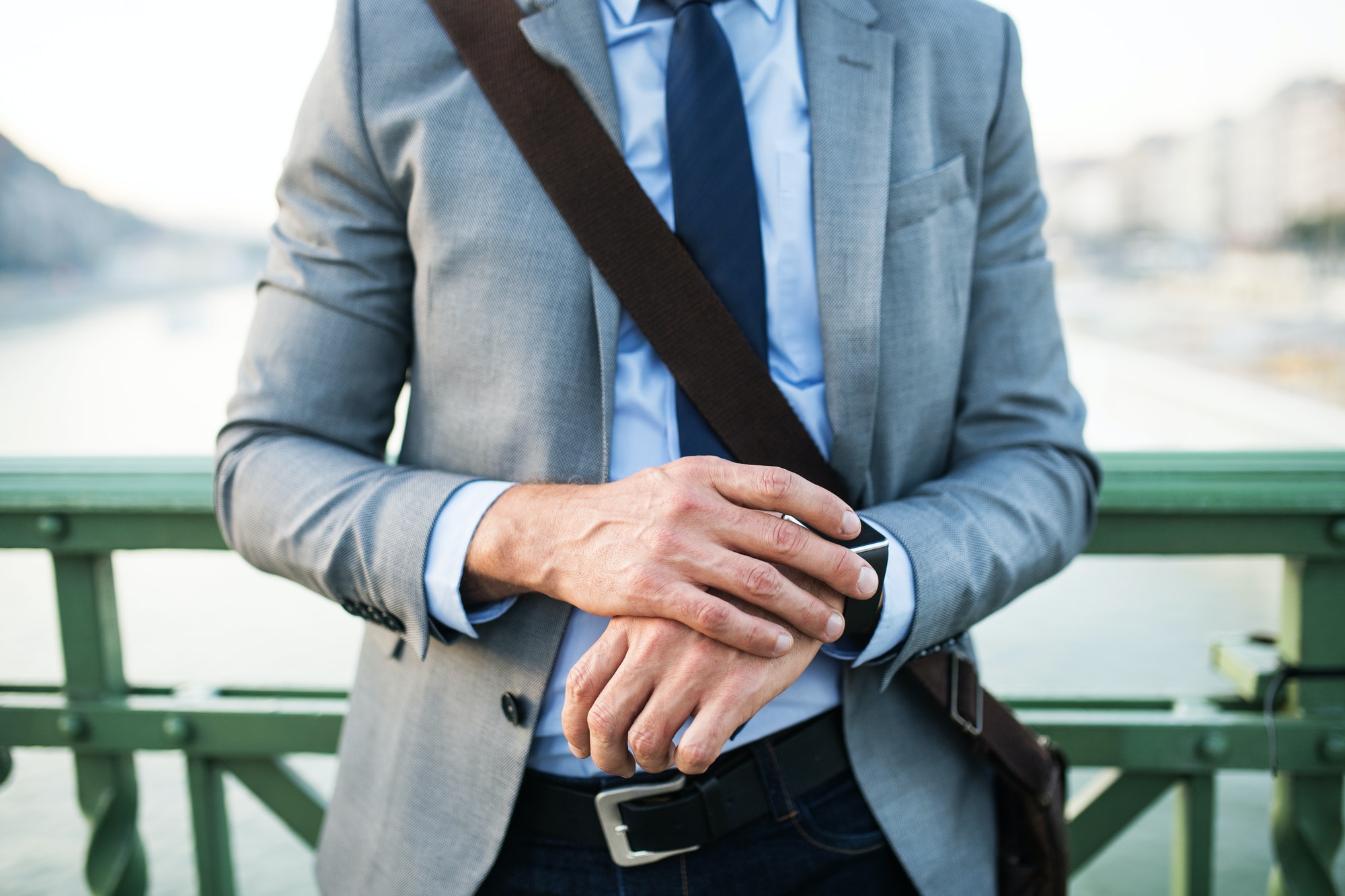 Businessman with smartwatch in a city.